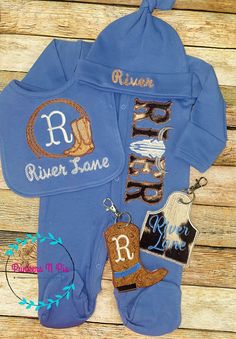 "Baby Boy footed sleeper perfect baby shower gift and/or bringing baby home from hospital! Baby's 1st name (max 6 letters) is appliqued in faux fur cow print.  Cow skull will replace the best suited letter in the name A matching slate blue knot hat, and bib can be purchased  Matching Diaper Bag Tags are sold in separate listing  https://www.etsy.com/shop/PunkersNPie?ref=seller-platform-mcnav&section_id=41059157 Description: Footed Sleeper is slate blue with snap closures See Size Chart; Bodysuits are 6.0 - 6.5 oz. 100% Ring spun combed cotton with zipper front Knot Hat is slate blue and fits NB-3 months.  First name only  BIB has single letter monogram in lasso and cowboy boots frame 11\" long / 8.5\" wide; velcro closure; 100% cotton backed in chenille Design is machine embroidered and fi Baby Shower Gifts Boy, Western Baby Gifts, Baby Monogram Ideas, Newborn Cowboy Outfit, Western Baby Boy Shirt, Western Baby Boy Blanket, Baby Boy Cowboy, Western Infant Clothes, Bringing Baby Home