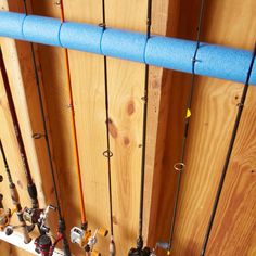 several fishing rods are lined up against the wall