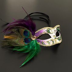 The masquerade mask comes in Mardi Gras for women and the peacock inspired purple green mask for women has arching feathers. This masquerade mask is great for any occasion. Luxury Artistic Masks For Mardi Gras, Mardi Gras Masks And Prosthetics, Green Eye Mask For Masquerade, Green Masks For Carnival Costume Party, Green Masquerade Mask For Mardi Gras, Mardi Gras Costume Masquerade Mask, Multicolor Mardi Gras Costume Masks, Mardi Gras Multicolor Costume Masks, Green Masquerade Mask For Mardi Gras Party