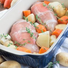 meat and vegetables in a casserole dish with carrots, potatoes and parsley