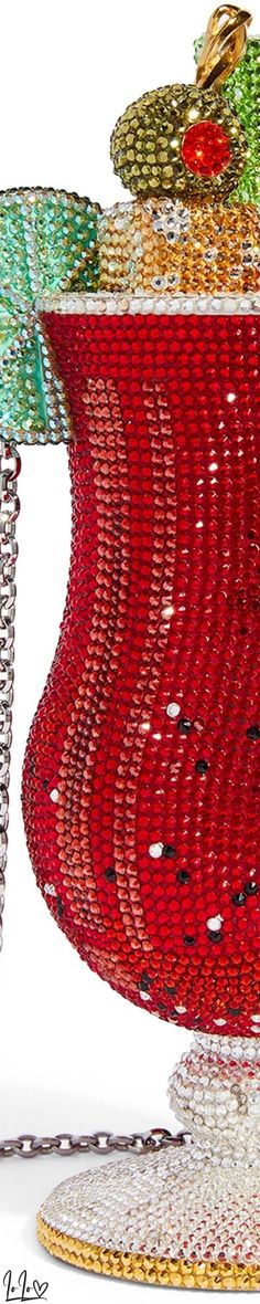 a red vase with many different colored beads on it's sides and a chain hanging from the side