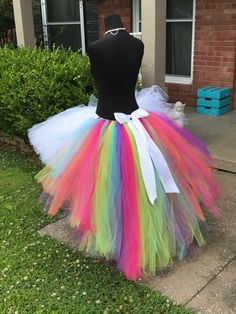 a dress made out of colorful tulle and white bow on the waist, sitting in front of a house