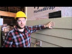 a man wearing a hard hat standing next to a house