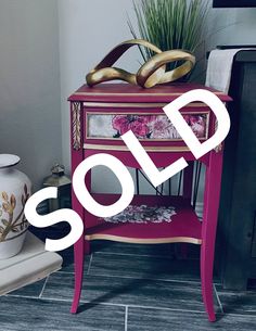 a pink and gold side table with a sale sign in front of it that says sold