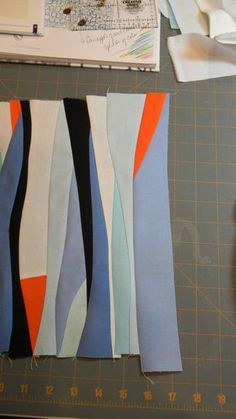 several pieces of fabric are laid out on a cutting board