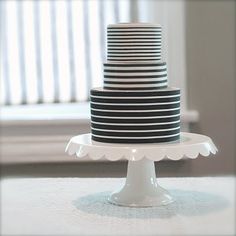 a black and white striped cake sitting on top of a table next to a window