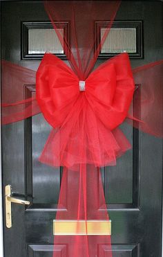 a red bow is hanging on the front door