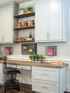 a kitchen with white cabinets and wooden counter tops