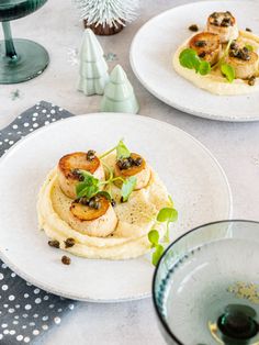 two white plates topped with food on top of a table