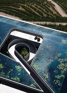 an aerial view of a building in the middle of a field with water lilies