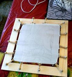 a wooden frame sitting on top of a table next to a red cloth covered floor