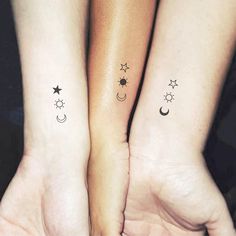 two small tattoos on their arms with stars and crescents in the sky above them