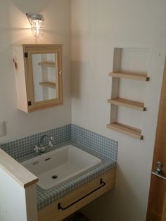 a bathroom with a sink, mirror and shelving unit in the corner on the wall