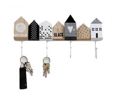 a row of wooden houses hanging from hooks on a wall with key holders attached to them