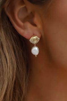 Our designer's favorite new style: the SEASIDE SHELL PEARL STUDS. With a delicate golden scallop shell stud and a naturally shaped freshwater pearl drop, these earrings showcase the beauty of organic elements in a sophisticated way. Material: Gold plate brass, freshwater pearl, sterling silver post SKU: E1666 Seashell Pearl Earrings, Summer Wishlist Products, Gold Shell Earrings, Seaside Clothes, Cancun Bachelorette, Gold And Pearl Earrings, Organic Elements, Pearl Beach, Scallop Shell