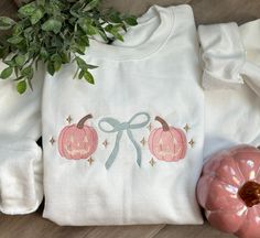 Get ready to embrace the "grandmillenial" trend this Halloween with our embroidered crewneck! Made from 100% cotton, this girly, stylish, and super comfy top adds a touch of whimsical charm to any Fall outfit. Our Grandmillenial Jack-o-lanterns are machine embroidered with the perfect shades of pink, blue and just the right amount of gold.  For best results wash inside out, cold water and lay flat to dry. Warm iron inside out if needed. Grandmillenial Halloween, Embroider Ideas, Boutique Shirts, Halloween Crewneck, Preppy Southern, Embroidered Crewneck, Birthday Wishlist, Simple Trendy Outfits, Comfort Colors Tee