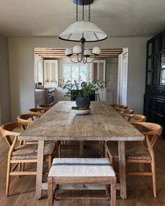 a dining room table with chairs and a potted plant on top of the table