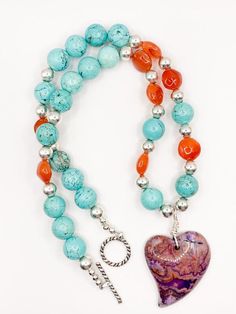 ADORABLE necklace!! Perfect for a romantic night out!! This PCJ designed and handmade necklace consists of a purple crazy lace agate heart focal wire wrapped with turquoise magnesite, orange carnelian flat round beads and sterling silver beads. Measures 20.5" in length. - Sterling silver - Genuine semi-precious gemstones - Measures 20.5" - Handmade by PCJ Orange Carnelian, Romantic Night, Crazy Lace Agate, Heart Soul, Lace Agate, Handmade Necklace, Precious Gemstones, Sterling Silver Bead, Semi Precious Gemstones