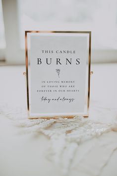 this candle burns sign is sitting on the floor in front of a window with white curtains