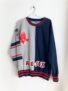 a red sox sweater hanging on a wall