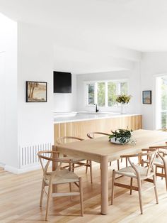 a dining room table with six chairs and a bowl of flowers on the centerpiece