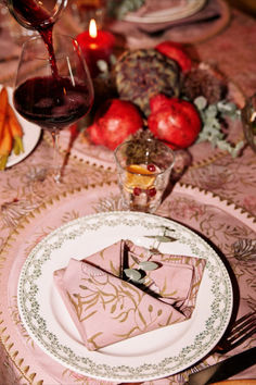 the table is set with pink napkins and silverware