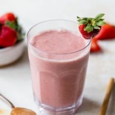 a smoothie with strawberries on the side