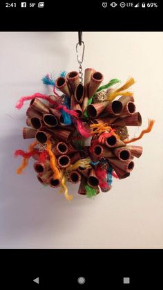 a bunch of sticks hanging from a hook on a wall with some colorful yarn around them