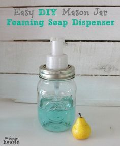 a bottle with soap on it sitting next to a lemon and a sponge dispenser