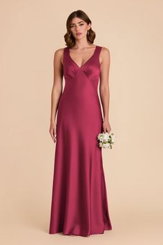 a bridesmaid in a long, deep pink dress with straps and a low v - neckline