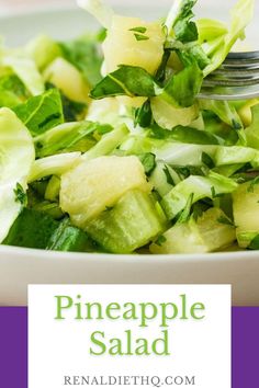 a white bowl filled with green vegetables and topped with pineapple salad on a purple background