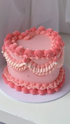 a three layer pink cake with ruffles on top