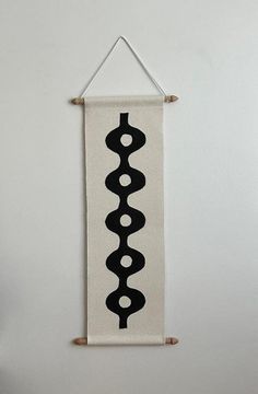 a white wall hanging with black circles on it