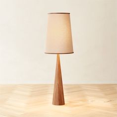 a wooden table lamp on top of a hard wood floor