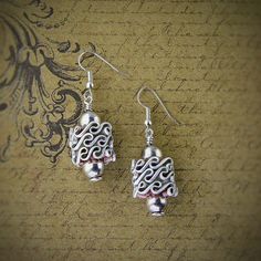 the earrings are made from silver wire and have swirly designs on each earring