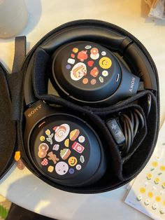 two black headphones sitting on top of a table