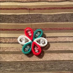 two pieces of brooch sitting on top of a striped cloth