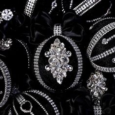 a close up view of some brooches on a black cloth with diamonds and pearls