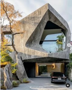 a car is parked in front of a house with an unusual shaped window on the side