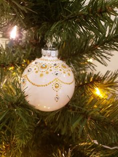 a white ornament hanging from a christmas tree