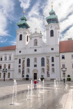 a large white building with two towers and water fountains