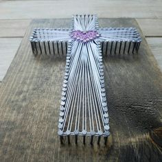 a metal cross sitting on top of a wooden table