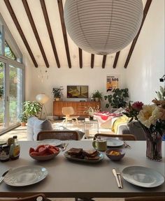 a dining room table with plates and bowls on it