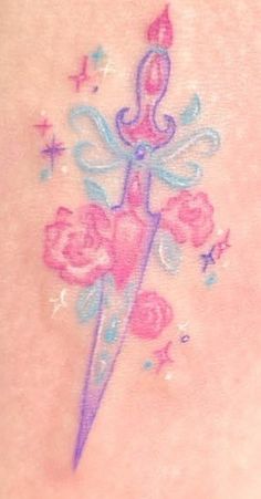 the back of a woman's stomach with a pink and blue tattoo on it