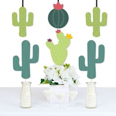 a table topped with vases filled with flowers and cactus decorations