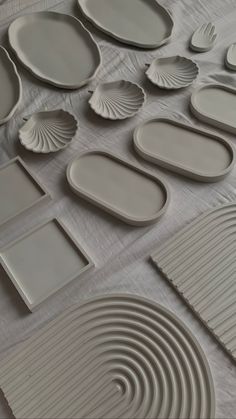 many plates and trays are laid out on a tablecloth covered with white paper