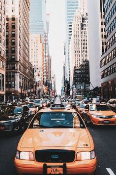 a busy city street filled with lots of traffic and tall buildings on either side of the road