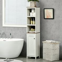 a white bath tub sitting next to a bathroom sink under a window in a room