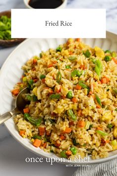 fried rice with peas and carrots in a white bowl