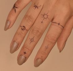 a woman's hand with tattoos on her fingers and the moon, stars, and sun